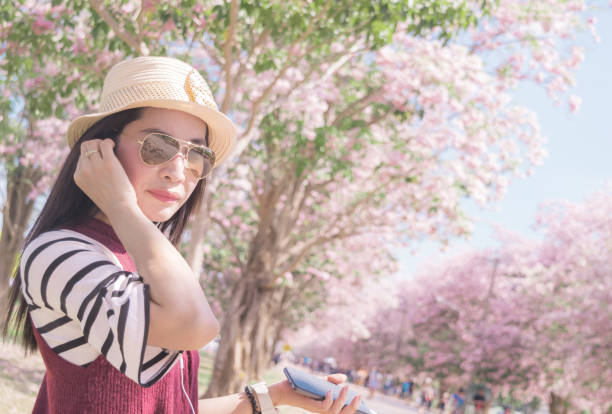 chapeau de femme asie musique écouteur touristique voir ciel et arbre trompette rose - romantic sky audio photos et images de collection