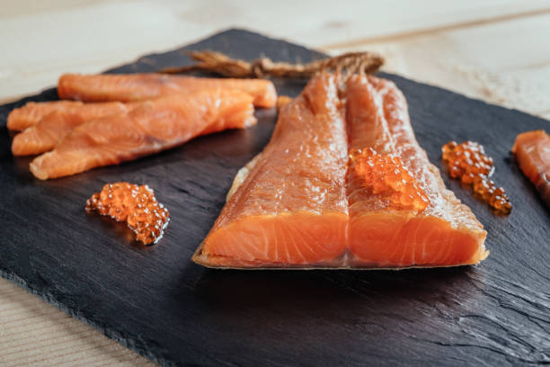 ahumados salmón pescado en un tablero de pizarra con caviar. vista superior en cortado rebanadas de salmón ahumado - pescado secado fotografías e imágenes de stock