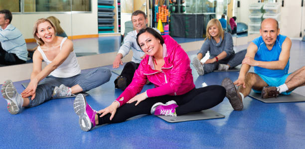 Three members of an aerobics class lying down doing stretches