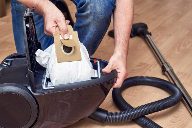 Removing full dust bag from a vacuum cleaner stock photo