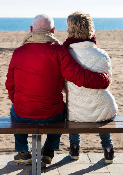 istock Mature couple sitting by sea 669560306