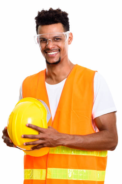 istock Thoughtful happy African man construction worker smiling while holding safety helmet 669560686