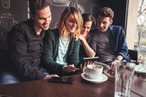 istock People Watching Video On Digital Tablet On Coffee Break In Popular Cafe 669566580