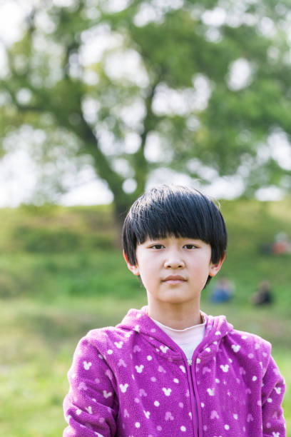 istock asian girl standing on the grass field 669566662