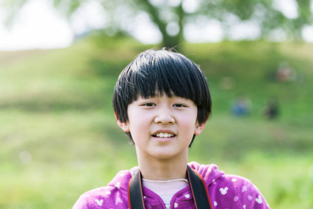 istock asian girl standing on the grass field 669566836