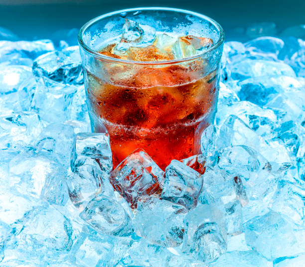 A glass in droplets with ice and a drink in ice blue