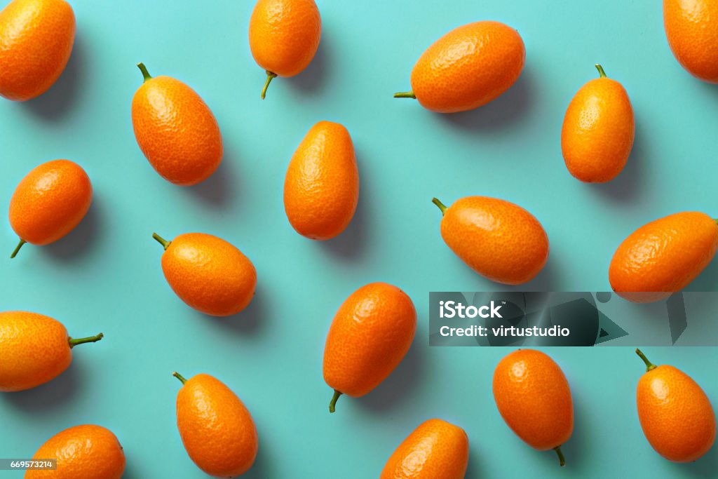 Flat lay pattern of fresh kumquats on a colorful background. Top view Kumquat Stock Photo