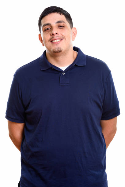 Studio shot of young happy Hispanic man smiling vertical shot