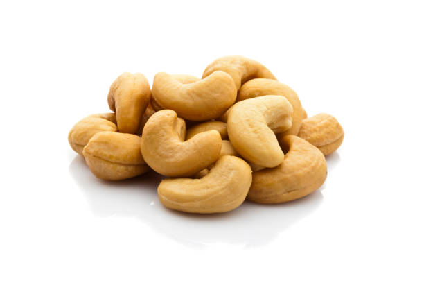 Front view of ashew nuts heap isolated on reflective white background.  DSRL studio photo taken with Canon EOS 5D Mk II and Canon EF 100mm f/2.8L Macro IS USM