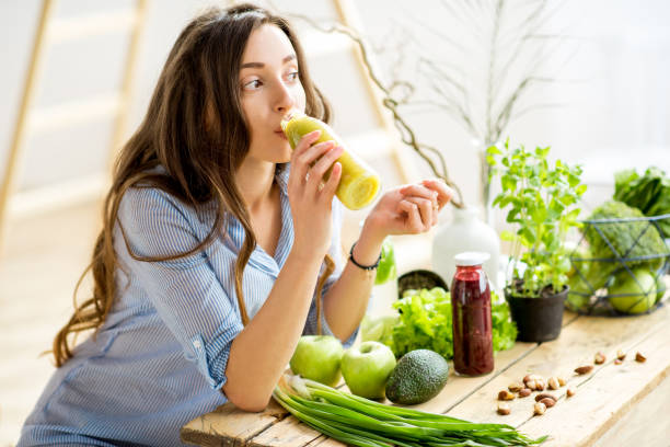 femme avec des aliments sains verte à la maison - juice drinking women drink photos et images de collection