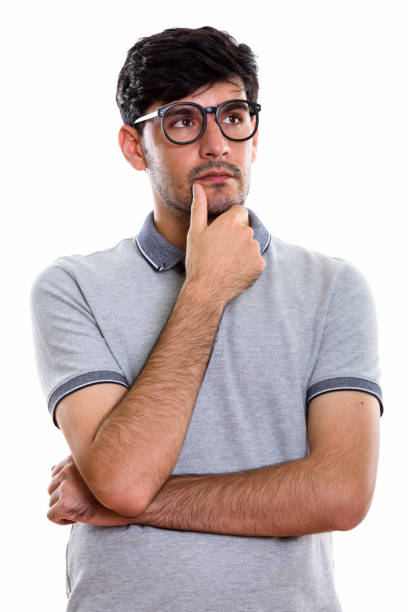 istock Studio shot of young Persian man thinking while looking up and wearing eyeglasses 669587962