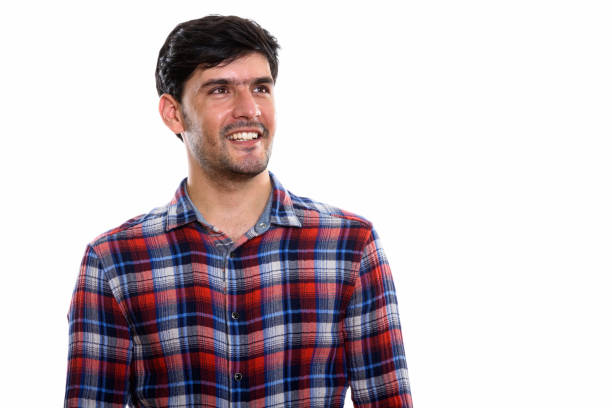 istock Studio shot of young happy Persian man smiling and thinking while looking up 669588190