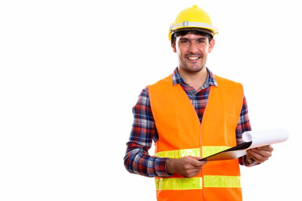 istock Young happy Persian man construction worker smiling while holding clipboard 669589012