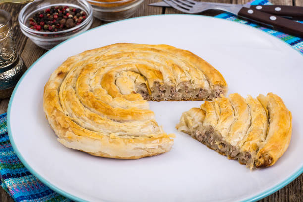 istock Meat burekas from puff pastry on wooden background 669592336