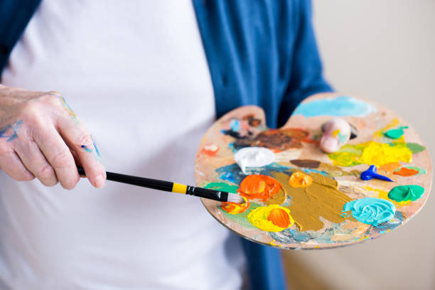 istock partial view of man holding paint brush and pallet 669606508