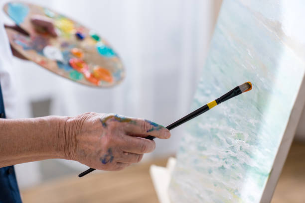 istock partial view of senior man drawing picture in workshop 669607368