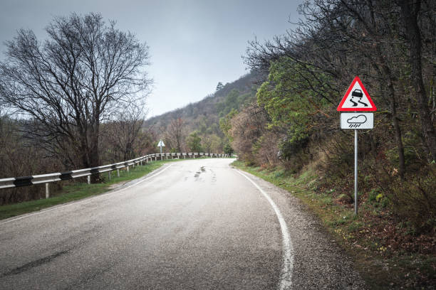 istock Slippery road, warning roadsign in rainy day 669614536