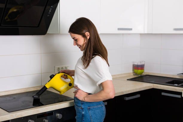 istock Woman cleaning kitchen with steam cleaner 669622056