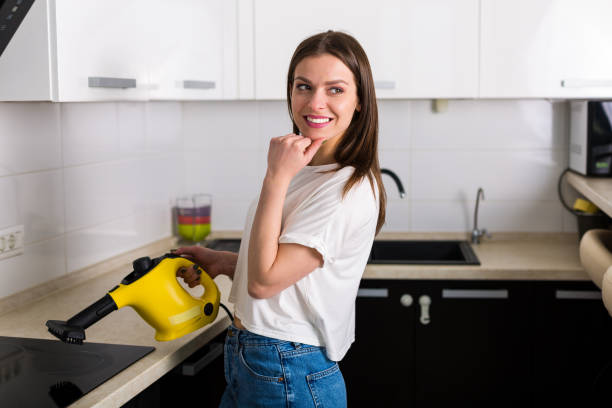 mujer limpieza cocina con limpiador de vapor - cleaning domestic kitchen counter top housework fotografías e imágenes de stock