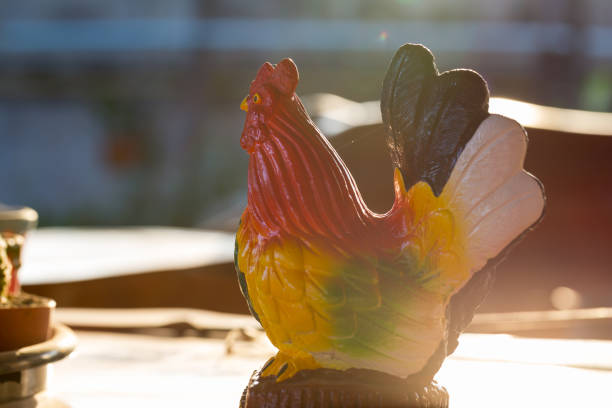 Chicken sculpture on wooden table in sunset time
