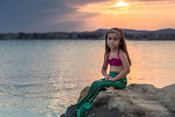 istock Little girl sitting on the cliff 669631924