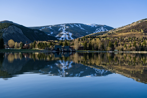 Beaver Creek Reflected in Nottingham Lake Avon Colorado - Scenic view with ski runs and snow reflected in lower valley lake where it's spring.