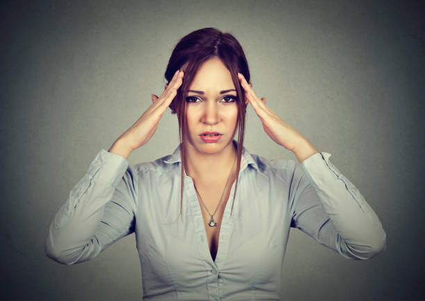 istock Stressed sad young woman with headache isolated on gray background 669638932