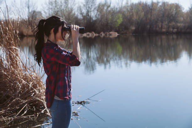 istock Young woman holding binoculars 669639386