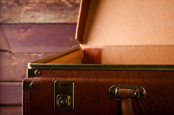 istock Old vintage, retro open suitcase on dark background. Front view 669641634