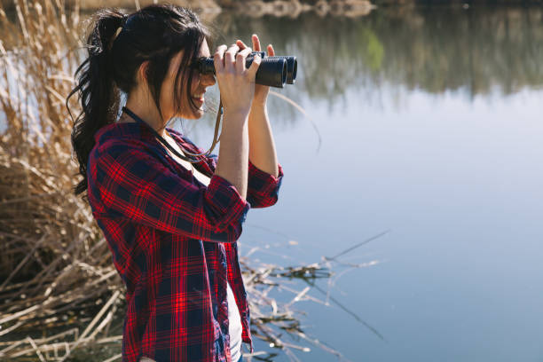 istock Young woman holding binoculars 669641666