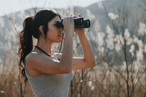 istock Young woman holding binoculars 669648286