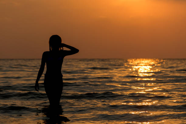 istock silhouette woman on the beach 669648854