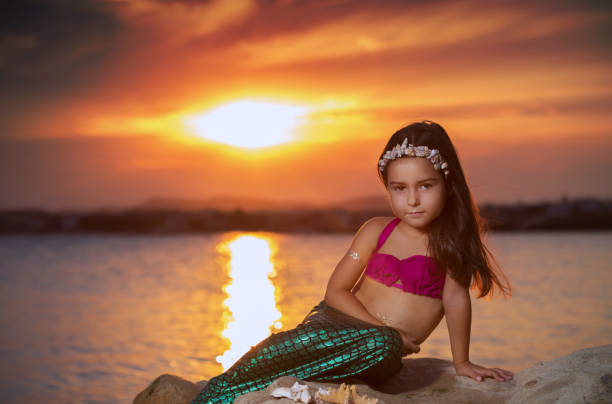 istock Little girl on the beach and setting sun 669651580