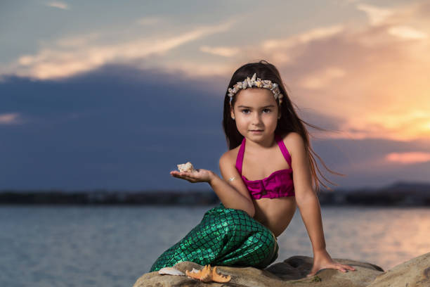 istock Little girl on the beach at sunset 669652166