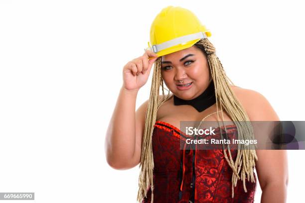 Young Happy Overweight Asian Construction Woman Smiling While Holding Safety Helmet And Wearing Sexy Costume Stock Photo - Download Image Now