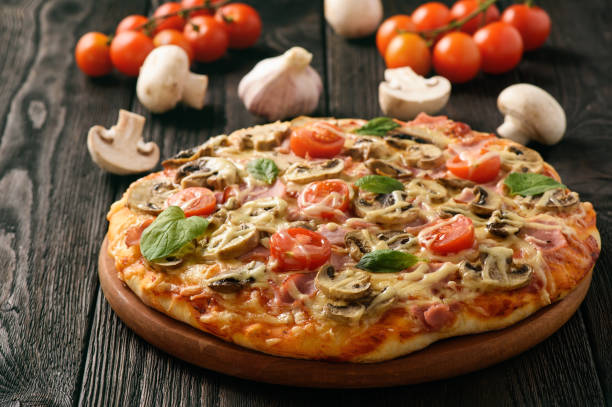 istock Homemade pizza with ham,mushrooms, tomatoes and cheese. 669666874