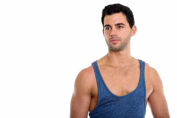 Studio shot of young handsome Hispanic man thinking while looking at distance horizontal shot