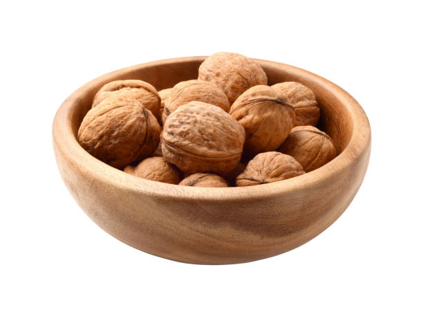 istock Walnuts in wooden plate isolated on white 669673634