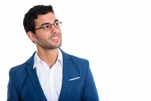 Close up of young happy Hispanic businessman smiling while wearing eyeglasses and thinking horizontal shot