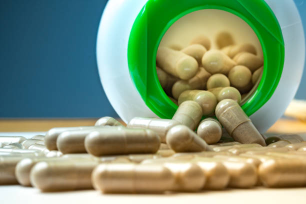 The common supplement for people who train regularly, l-arginine, shot in studio against a black background on a reflective surface.