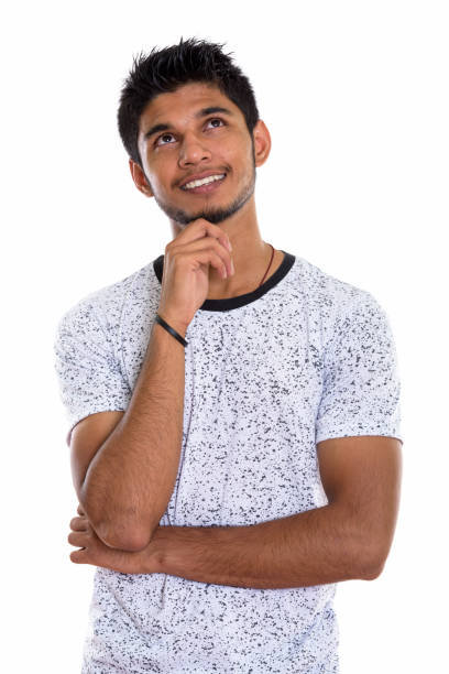 istock Studio shot of young happy Indian man smiling and thinking while looking up 669698466