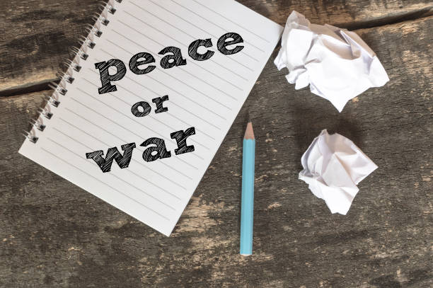 istock Peace or War text on a notebook with pen crumpled paper. 669699278