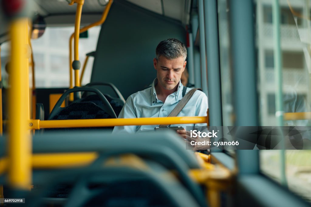 Businessman traveling by bus Confident businessman traveling by bus and using a digital tablet Bus Stock Photo