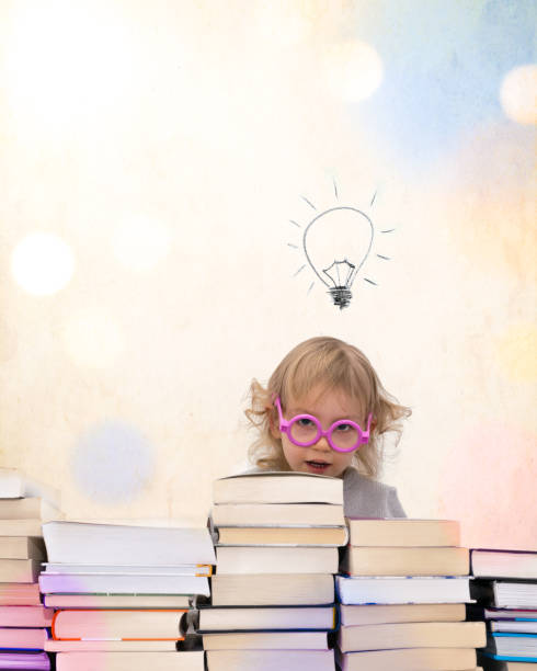 istock girl over stack of books bulb colorful 669705398