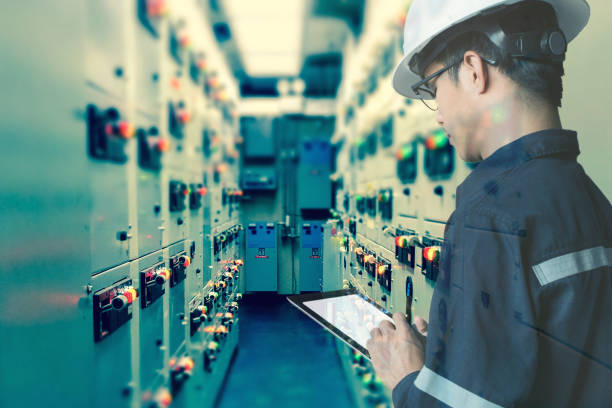 Double exposure of  Engineer or Technician man working with tablet in switch gear electrical room of oil and gas platform or plant industrial for monitor process, business and industry concept stock photo