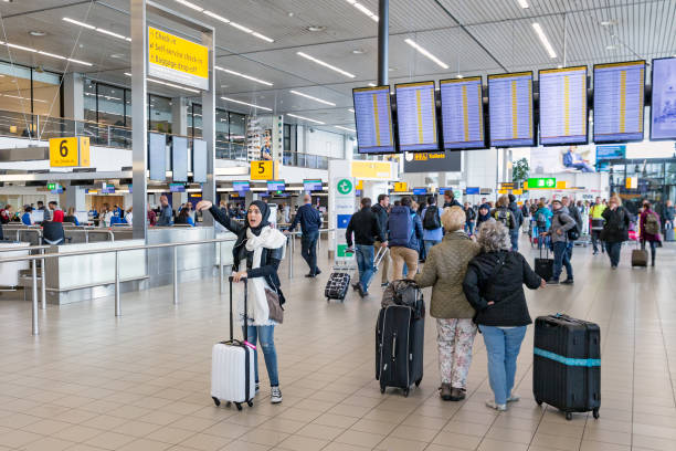 reisende und frau mit kopftuch am niederländischen flughafen schiphol - amsterdam airport stock-fotos und bilder