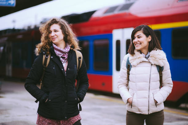istock Cheerful Girls At Train Station 669706402