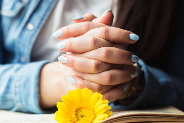 istock Girl's hands on a book with a yellow flower 669709654