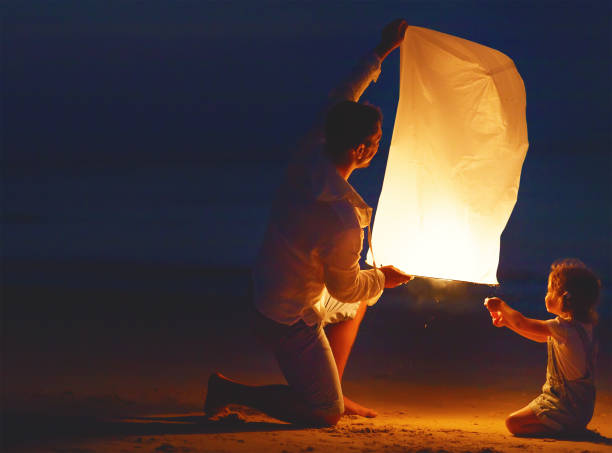 istock Family send air heavenly flashlight lamp in flight on beach 669709794