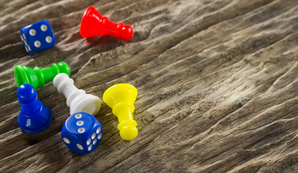 istock Dices and board game figure on wooden table 669712390
